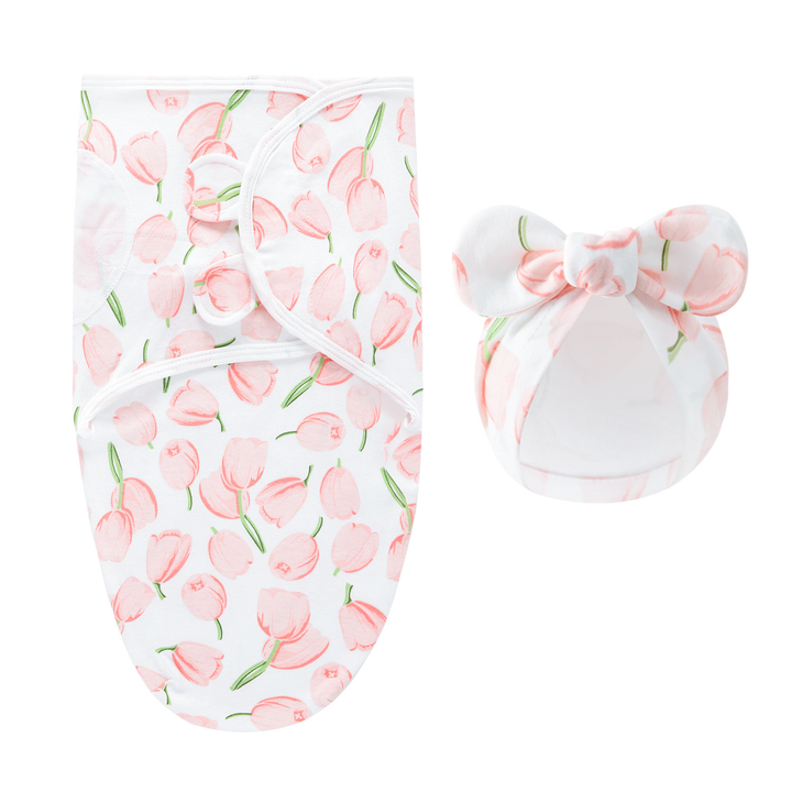 White swaddle blanket and matching bow hat with peach-pink tulips and green stems