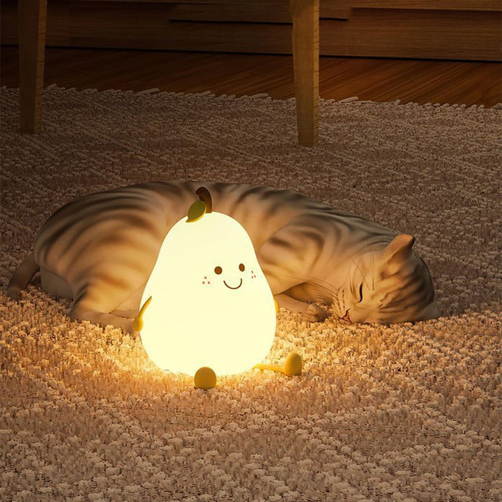 Warmly glowing pear-shaped night light on a rug beside a sleeping cat