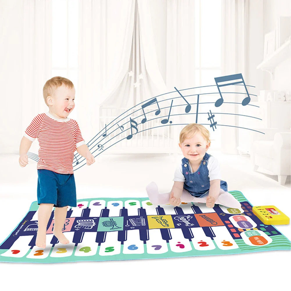 Two children playing on a piano floor mat, one standing and one seated