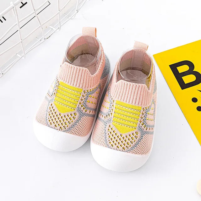 Pink baby slip-on shoes with yellow knit accents and white soles