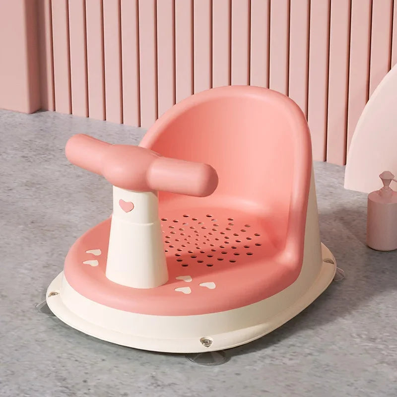 Pink baby bath seat with a rounded backrest and cream-colored base
