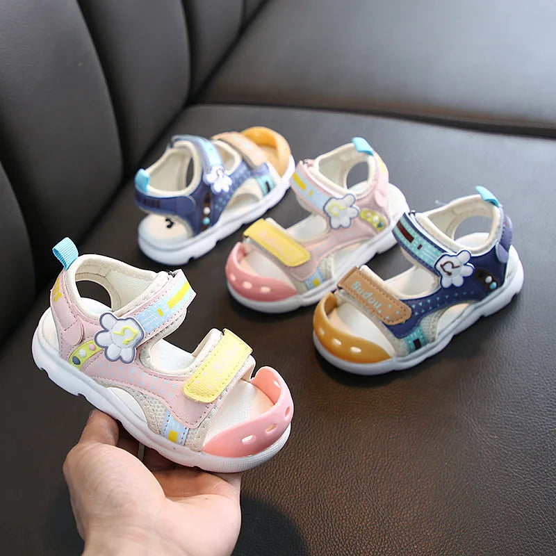 Pink and blue kids' sandals with flower accents, adjustable straps, and white soles