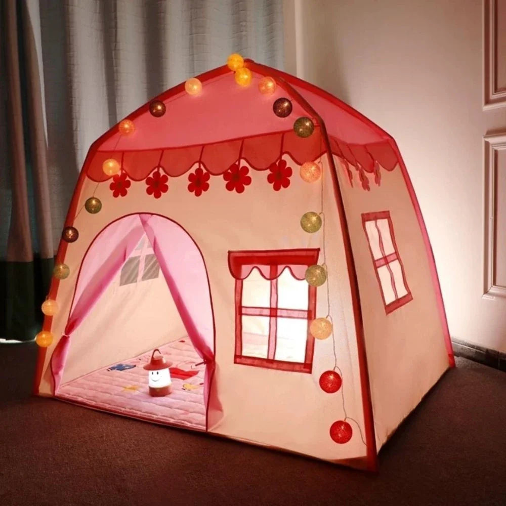 Pink castle play tent decorated with glowing string lights indoors