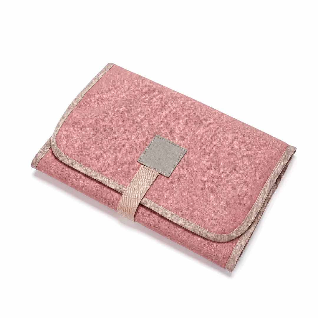 Pink changing mat folded with a square patch and beige edging