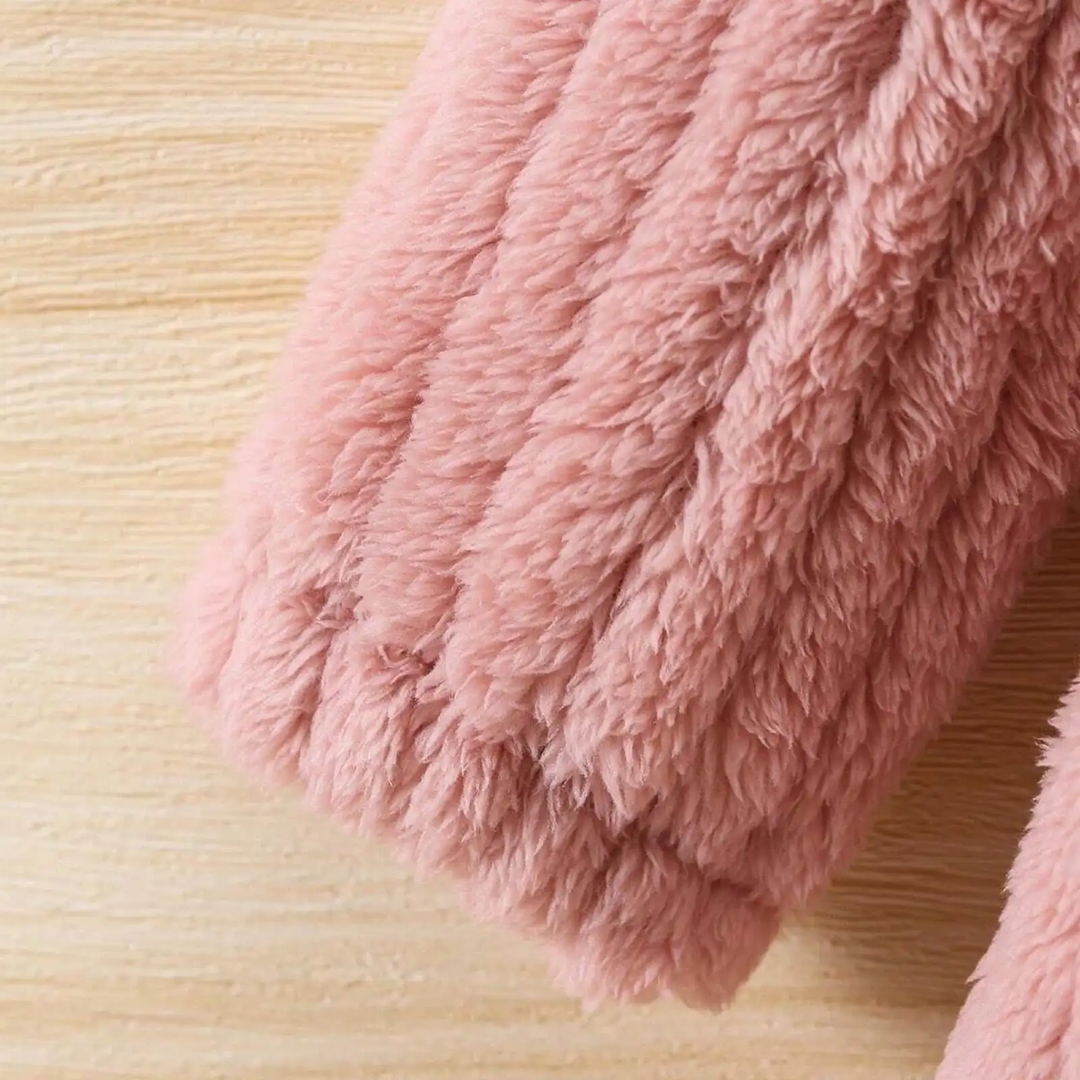 Pink winter coat sleeve showing plush texture and cuff stitching
