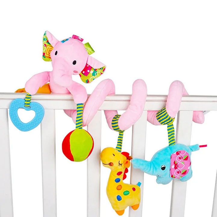 Pink elephant spiral toy on a crib rail with a heart, ball, giraffe, and blue animal.