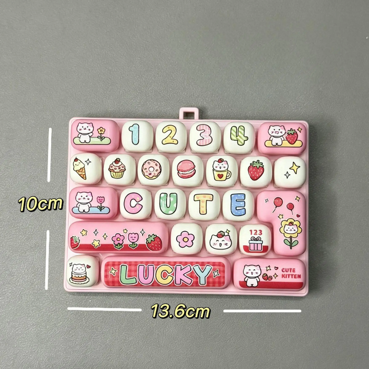 Pink fidget keyboard with letter and number keys, labeled 13.6 cm wide and 10 cm high