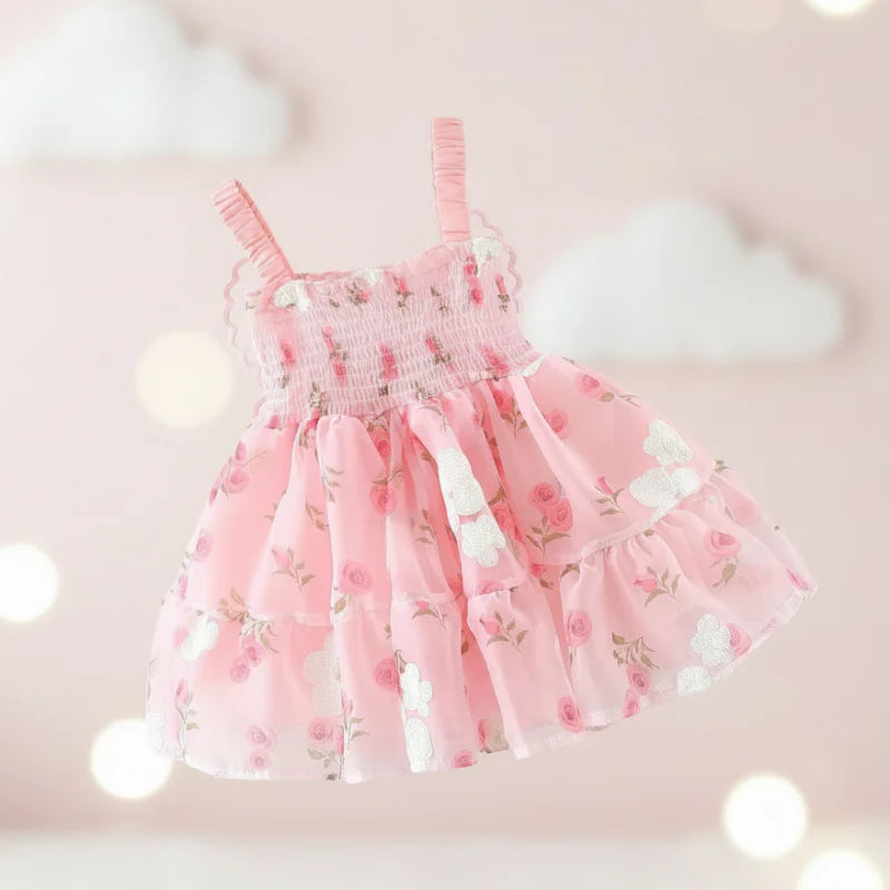 Front view of a pink floral baby dress with a smocked bodice and ruffled straps
