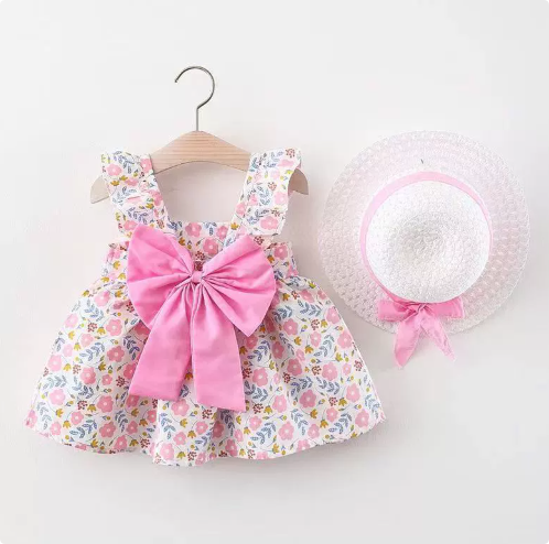Pink floral dress with an oversized pink bow and matching straw hat
