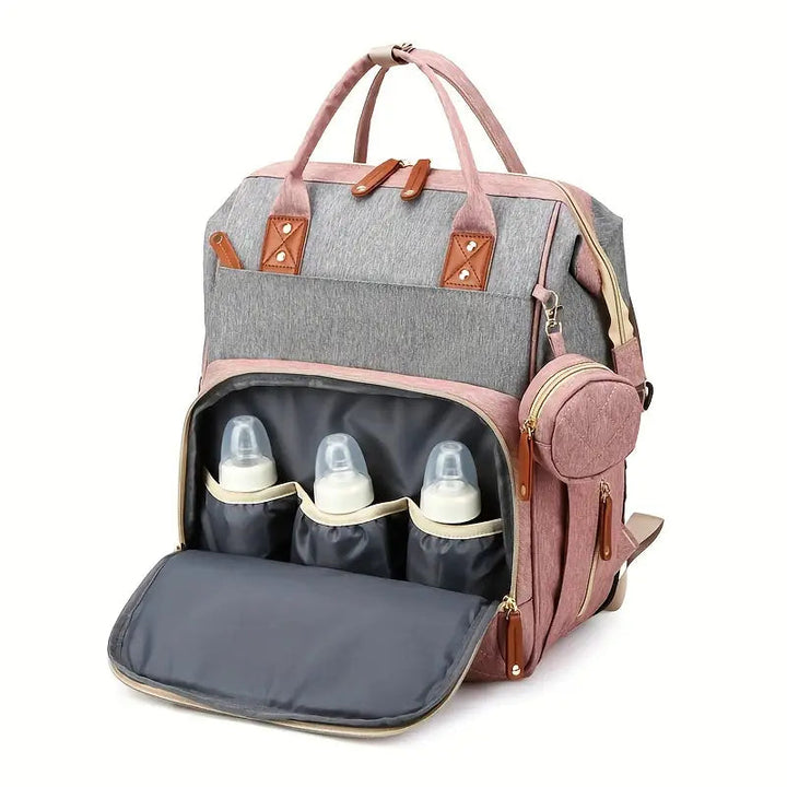 Pink-and-gray diaper backpack with its front compartment open to show three bottle pockets