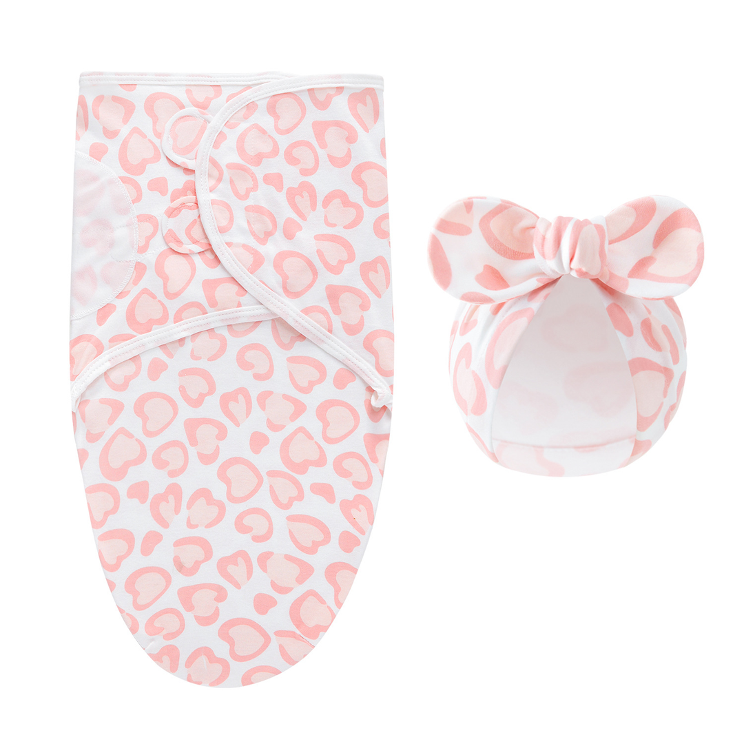 Pale pink swaddle blanket and matching bow hat with pink heart-shaped markings