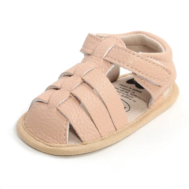 Pink baby sandal with interwoven toe straps and a hook-and-loop ankle closure