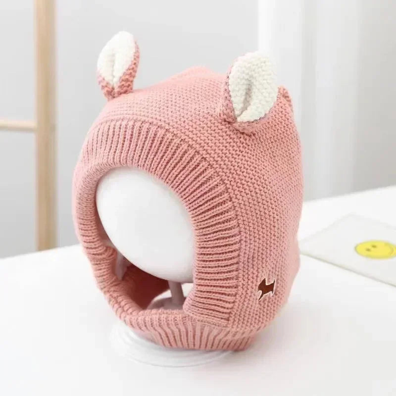 Pink knit balaclava with cream ears and a ribbed opening around the face