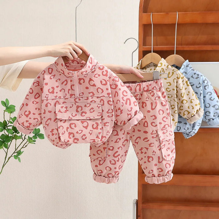 Pink leopard print pullover and pants with blue and beige color options behind them.