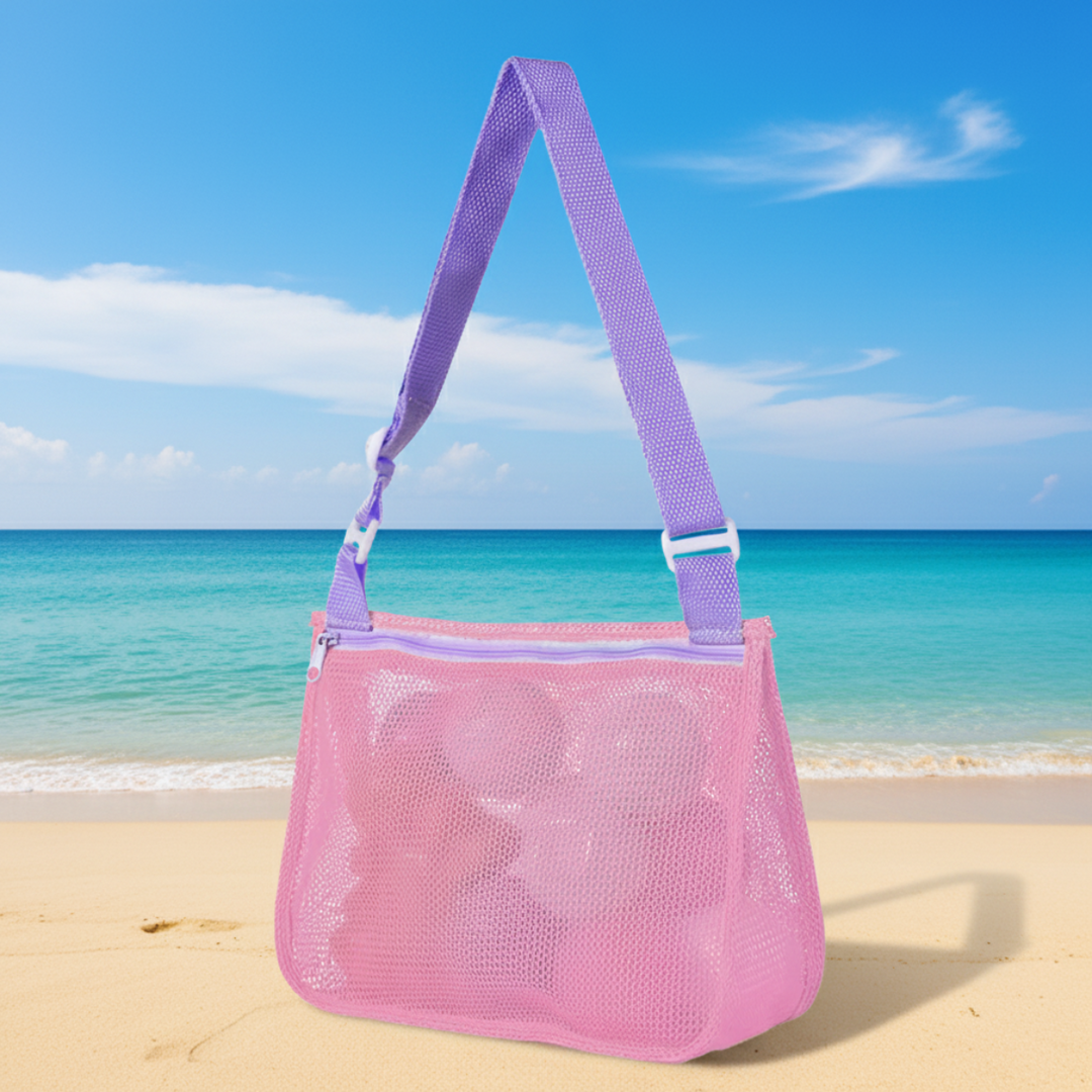 Pink mesh beach bag with a purple adjustable shoulder strap on the sand