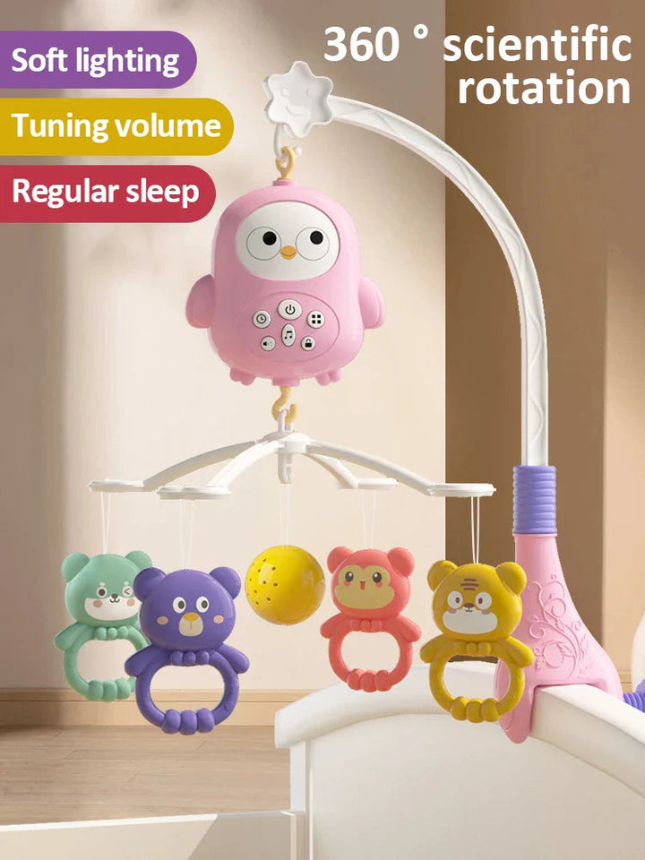 Pink owl musical mobile with animal-shaped hangers and a yellow ball above a crib.