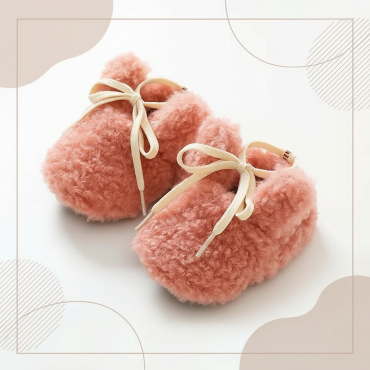 Pink plush baby shoes with cream laces and rounded ears