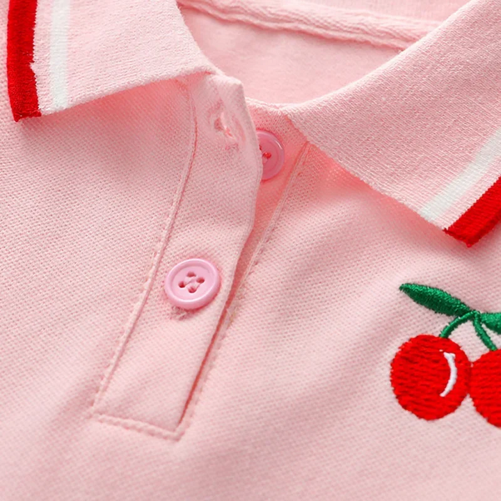 Pink polo dress neckline with matching buttons, red-striped collar and embroidered cherries.