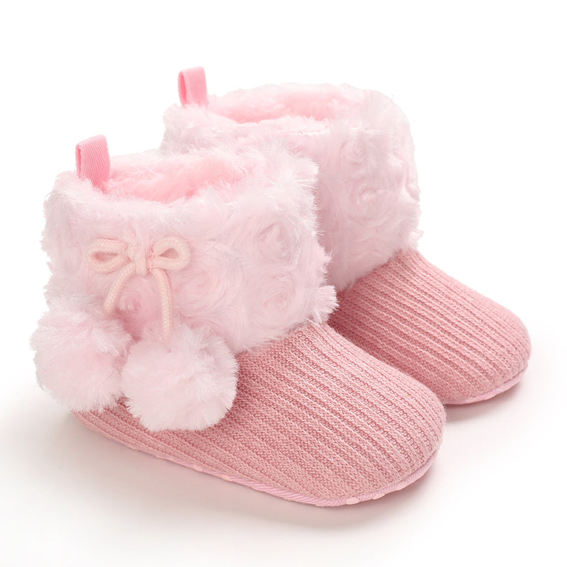 Pink baby boots with plush ankle cuffs and matching pom-poms