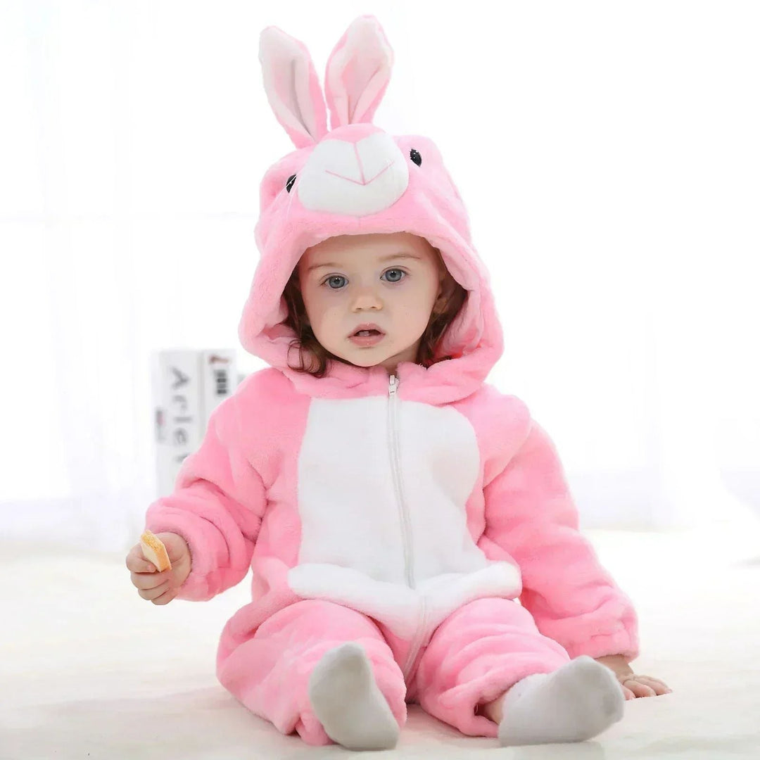 Baby seated in a pink rabbit onesie with upright ears and a white belly