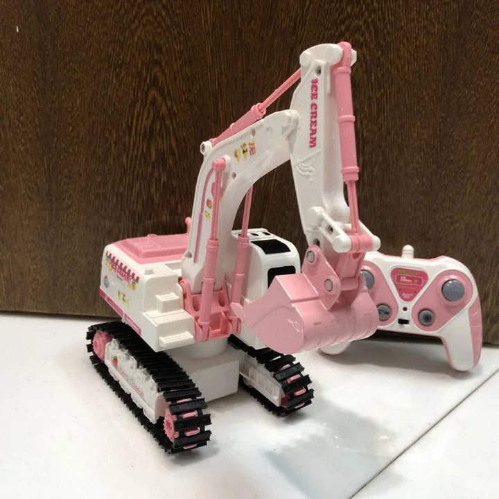 Pink-and-white toy excavator with its bucket lowered and matching remote beside it.