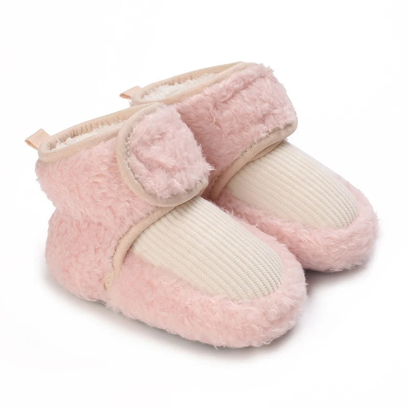 Pink baby shoes with cream ribbed front panels and plush ankle straps.