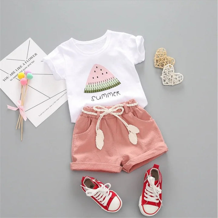 Pink shorts paired with a white short-sleeve watermelon T-shirt