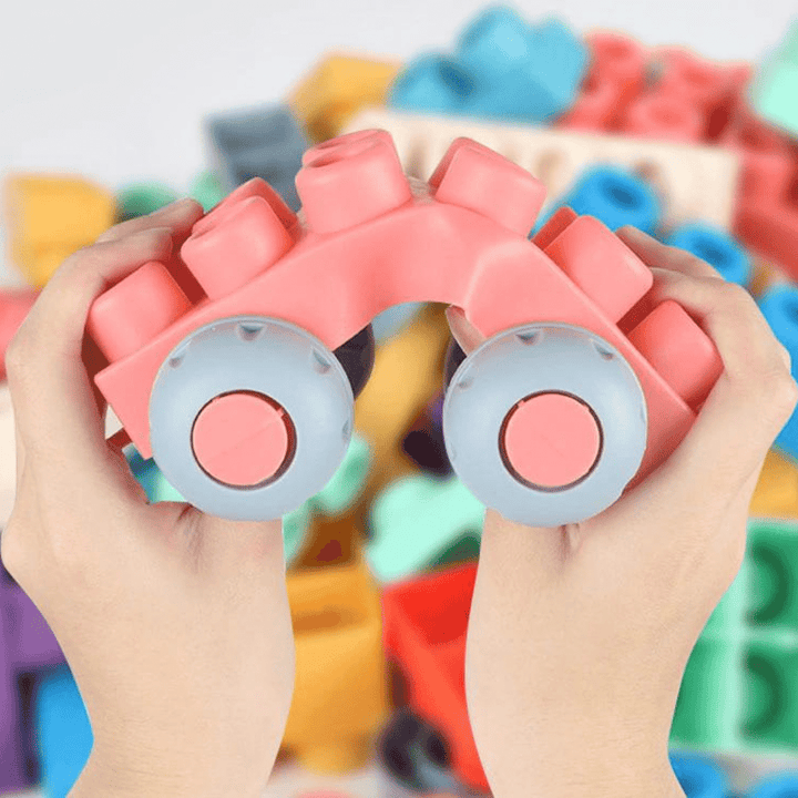 Hands bending a pink silicone block vehicle with gray wheels