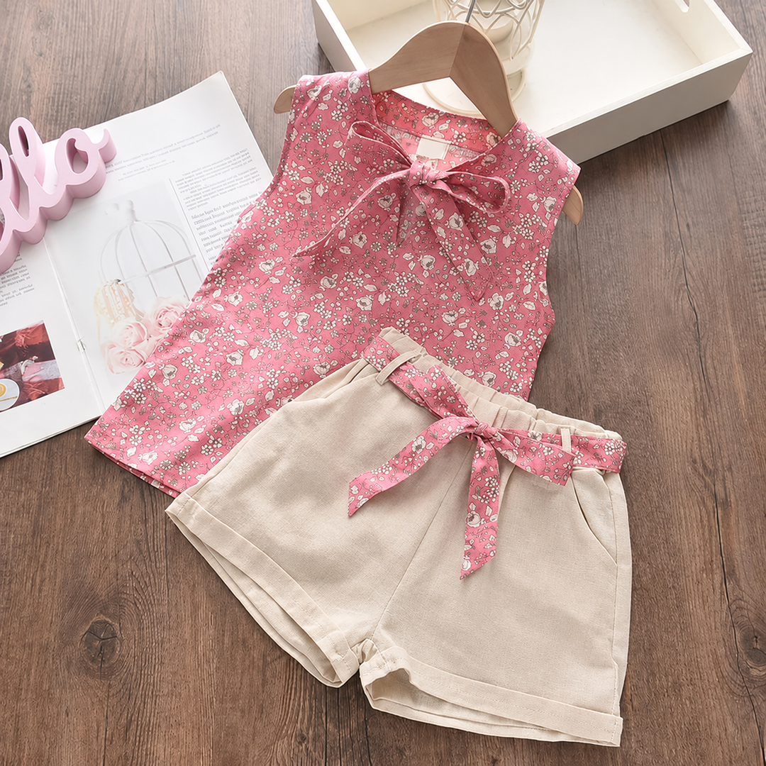 Pink floral top and cuffed beige shorts laid out as a matching two-piece outfit