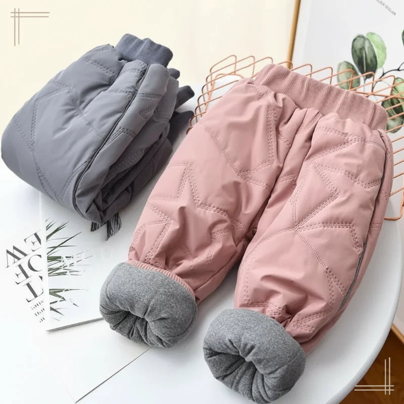 Pink winter pants with cuffs rolled up to show gray fleece lining beside folded gray pants