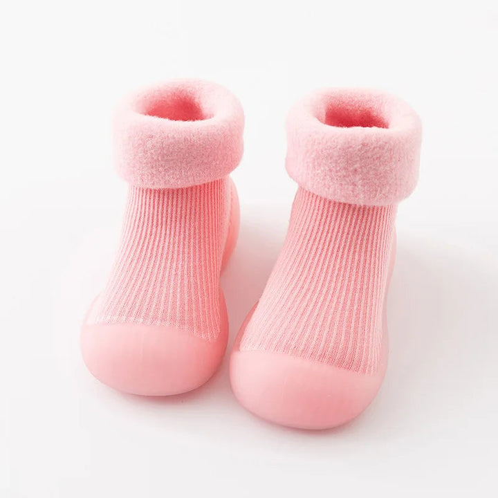 Pink sock shoes with plush folded cuffs and matching rubber soles.