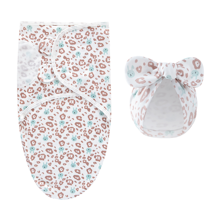 White swaddle blanket and matching bow hat with small pink and teal markings