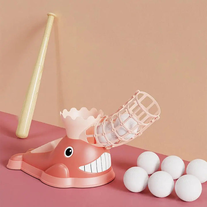 Pink whale-shaped baseball pitcher with a yellow bat and six white balls