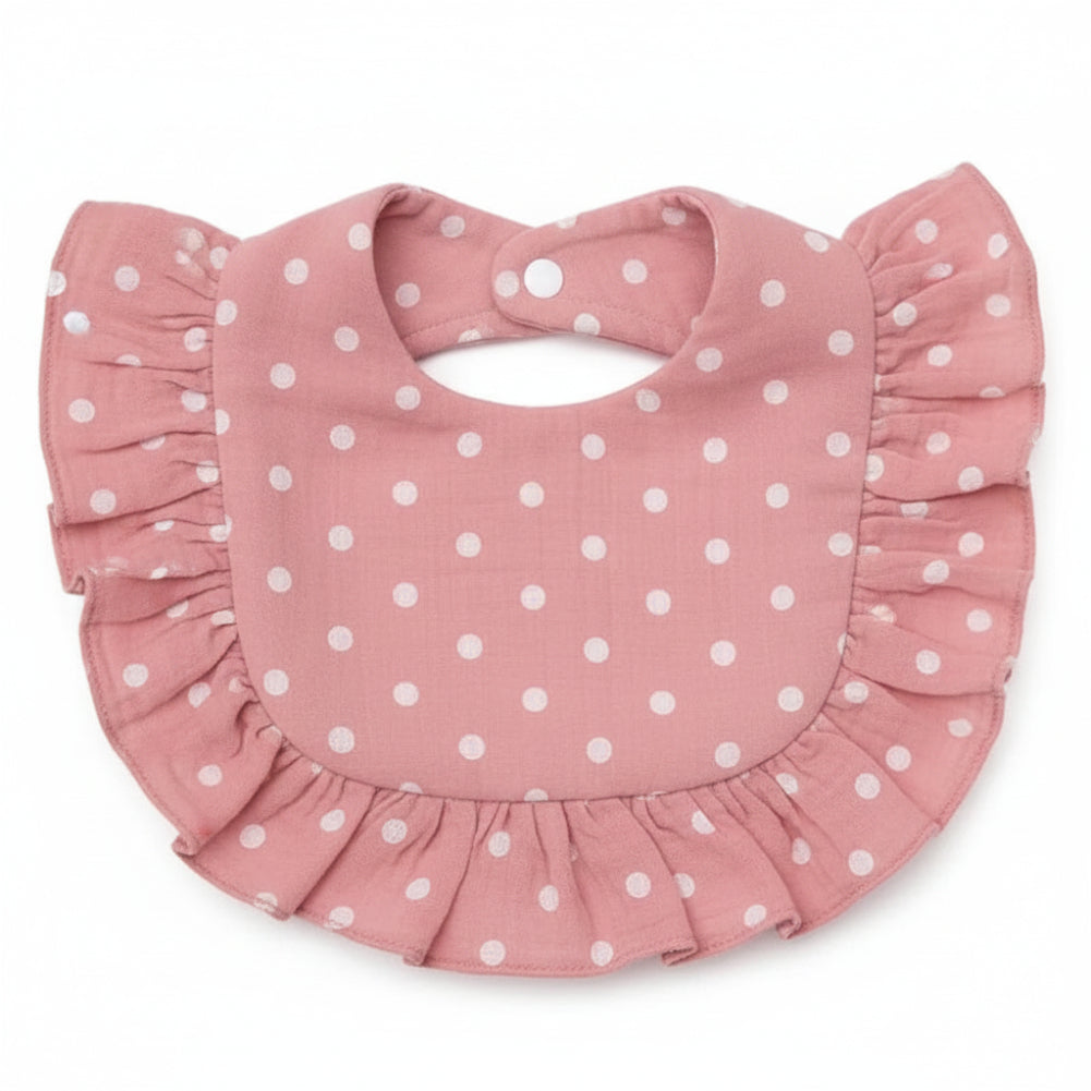 Pink cotton baby bib with white polka dots, ruffled trim, and neck snaps