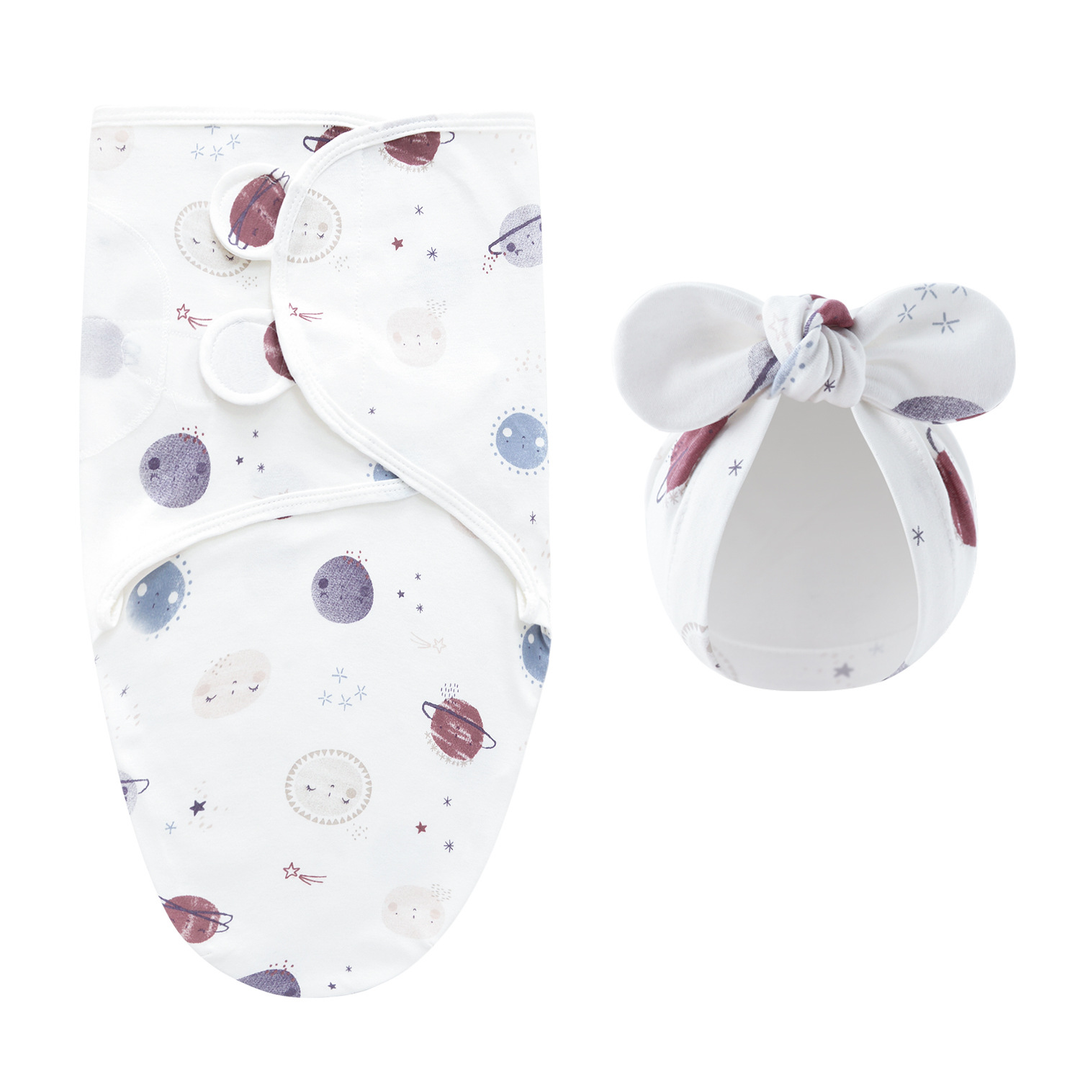 White swaddle blanket and matching bow hat with a colorful planet pattern