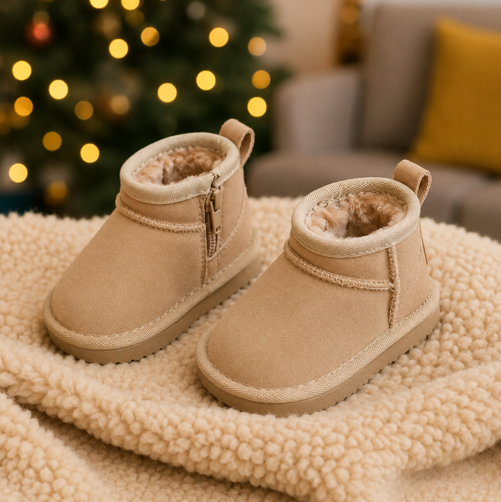 Beige plush-lined ankle boots resting on a textured cream blanket