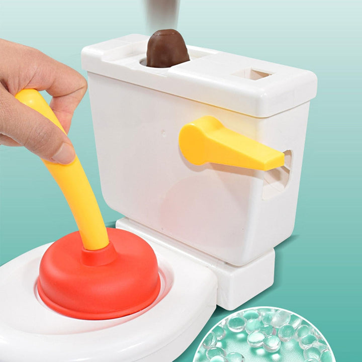 Hand pressing the red-and-yellow plunger on a white toilet game with pretend poop in the tank