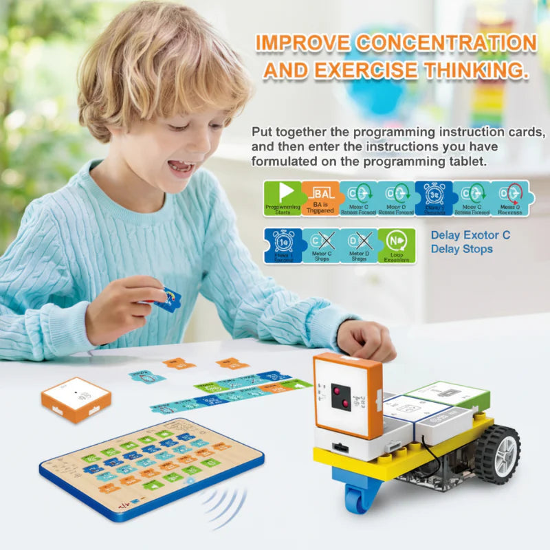 Child arranging programming cards beside a command board and wheeled robot