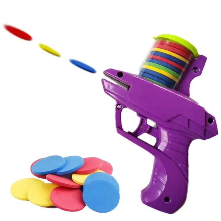 Purple toy blaster launching colorful discs beside a pile of soft foam discs.