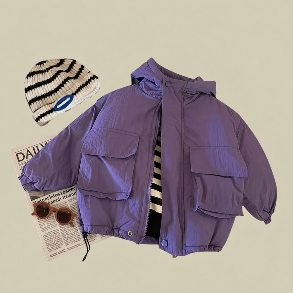 Purple kids' windbreaker with front flap pockets styled over a striped top