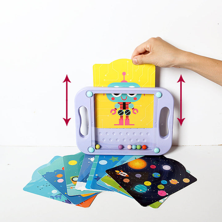 Hand sliding a yellow robot card into a purple maze board, with other illustrated cards below