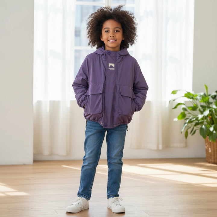 Child wearing a purple windbreaker with jeans indoors