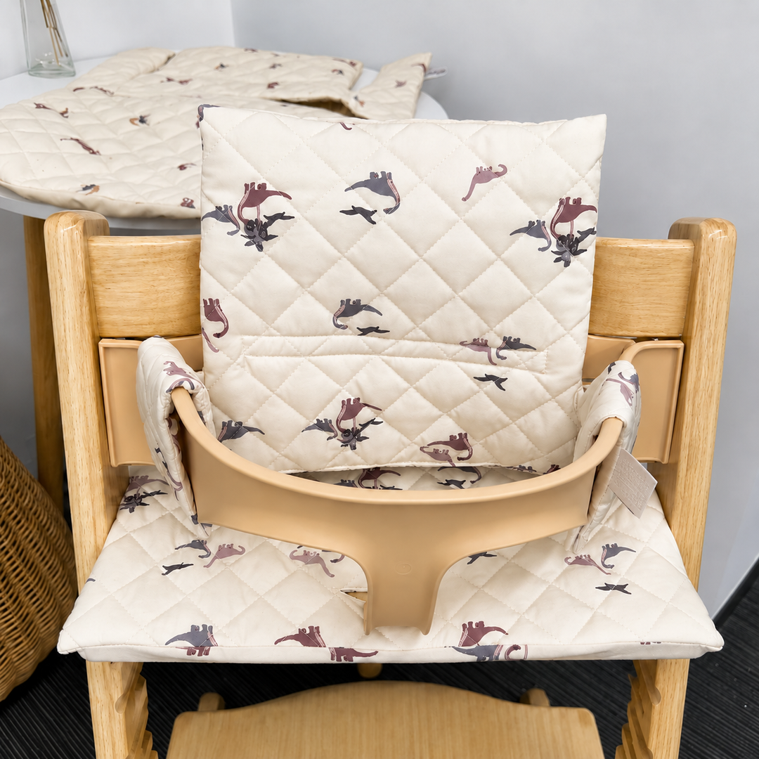 Cream quilted high chair cushion with a floral print on a wooden chair