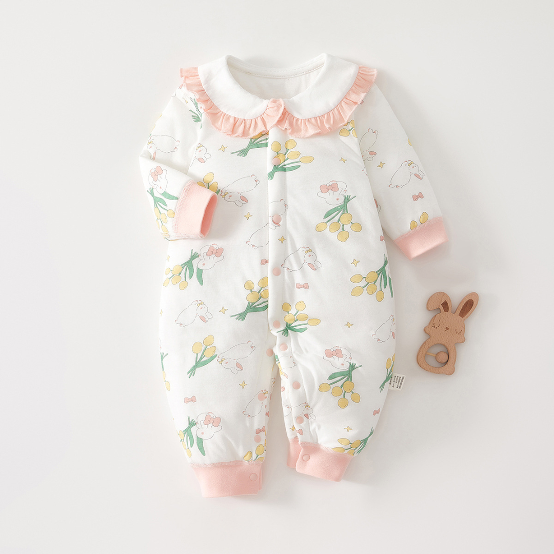 White baby pajamas with rabbit and flower prints, a pink ruffled collar, and matching cuffs