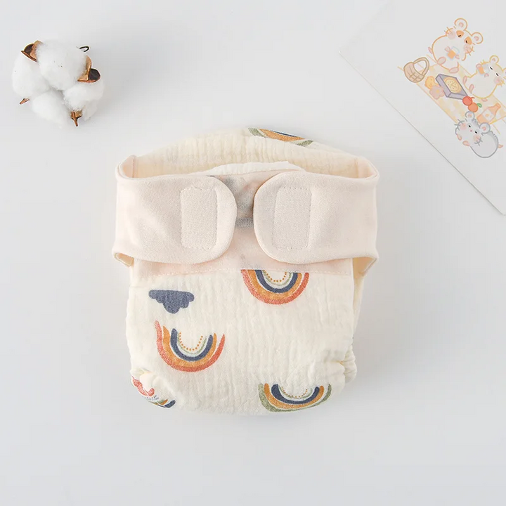 Rainbow-and-cloud cloth diaper with a cream hook-and-loop waistband