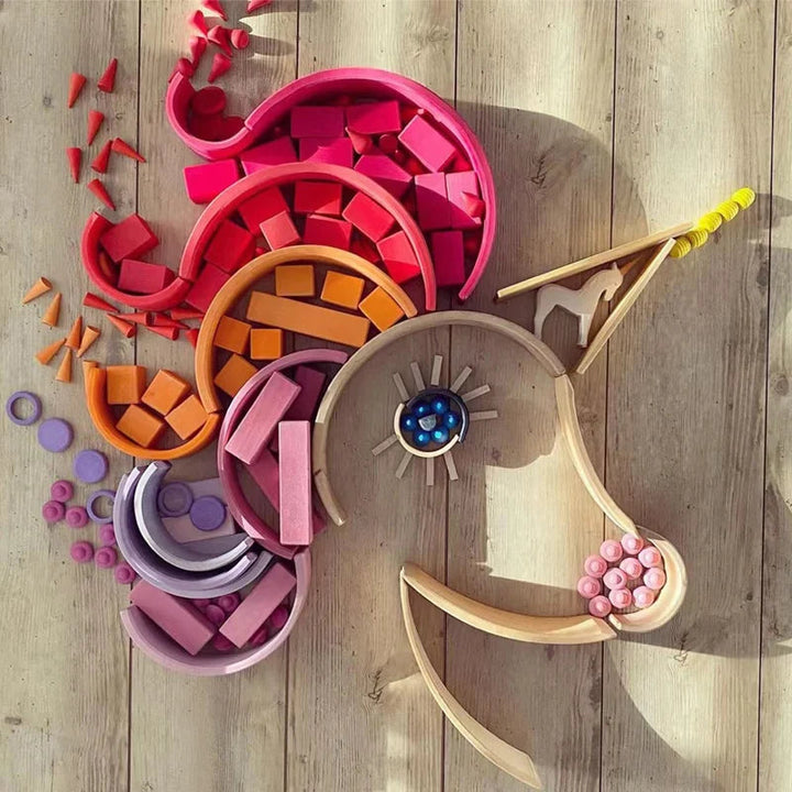 Pink, purple, and orange wooden shapes arranged along the mane of a unicorn-shaped outline