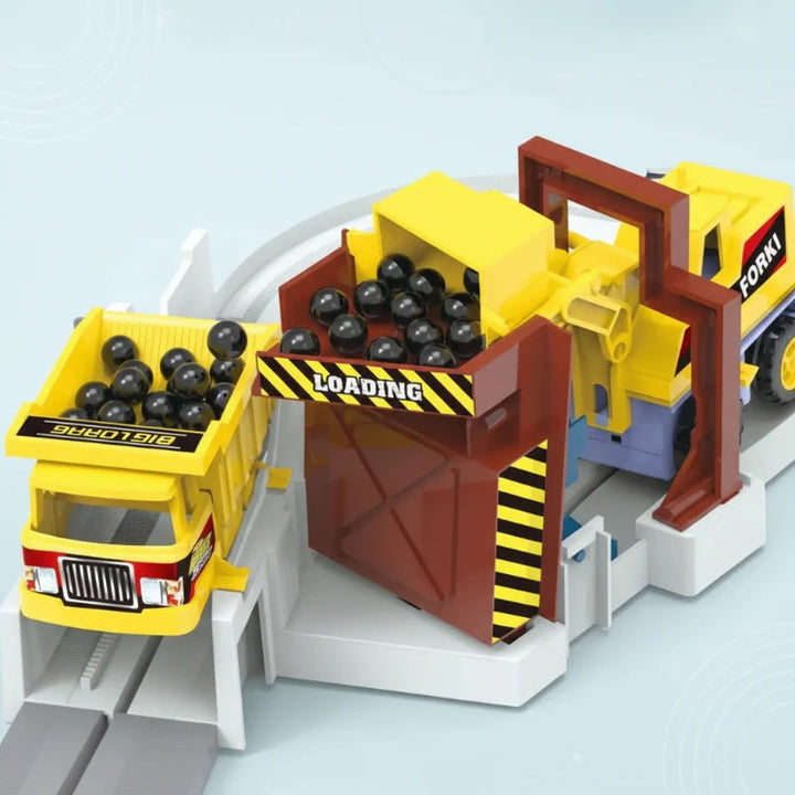 Yellow truck beneath a raised loading station filled with black play balls
