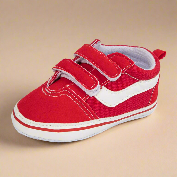 Red baby sneaker with a white side stripe, two straps, and a heel pull tab