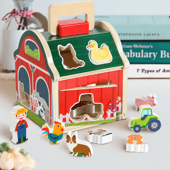 Wooden barn sorter on a tabletop with animal pieces, a farmer, and a tractor arranged around it.