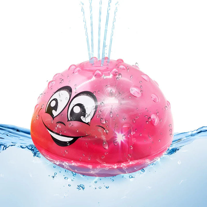 Red smiling bath ball spraying water upward while floating in water
